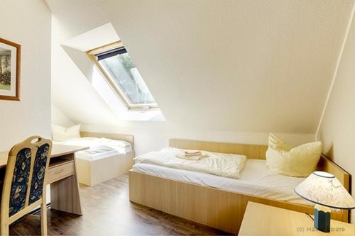 a bedroom with a bed and a desk in a attic at Am Deich 34 in Zingst