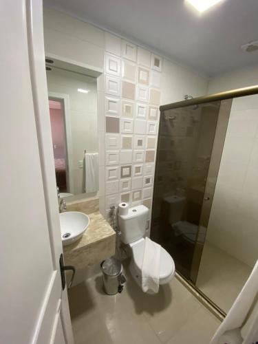 uma casa de banho com um WC, um lavatório e um espelho. em Pousada Vovô Nino em Gramado