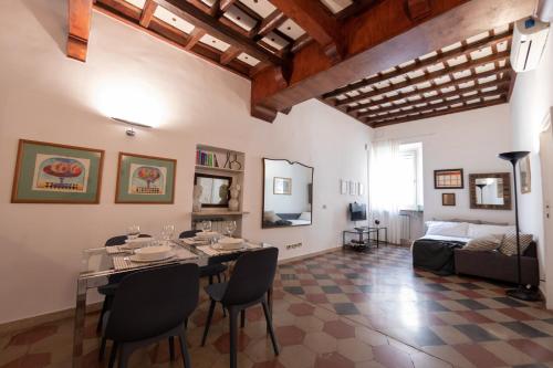 The Best Rent - Piazza di Firenze Apartment في روما: غرفة طعام مع طاولة وكراسي وأريكة