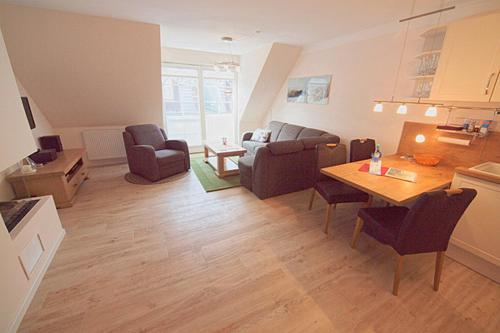 sala de estar con sofá, mesa y sillas en Les Belles, Haus Bastien, FW Noble, Whg 9 en Zingst