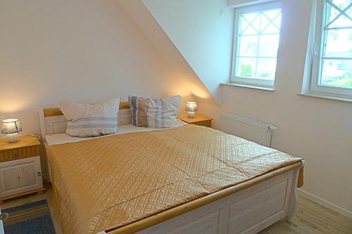 a bedroom with a large bed with two windows at Les Belles, Haus Bastien, FW Noble, Whg 9 in Zingst