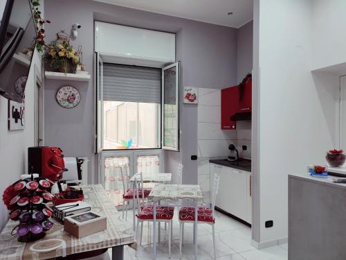 eine Küche mit einem Tisch und Stühlen sowie einem Fenster in der Unterkunft B&B May Dream in Neapel