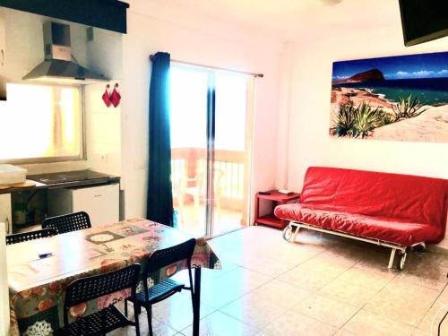 uma sala de estar com um sofá vermelho e uma mesa em Regina Pacis (VALLE-LUZ) em Puerto de la Cruz