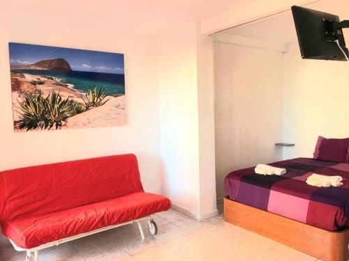 een slaapkamer met een bed en een stoel en een schilderij bij Regina Pacis (VALLE-LUZ) in Puerto de la Cruz