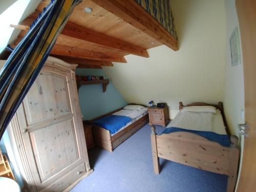 two twin beds in a room with wooden ceilings at FeWo Abendsonne in Prerow