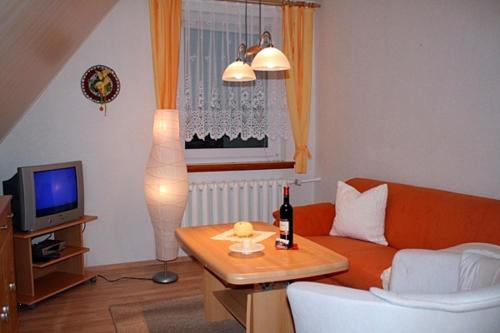 a living room with a orange couch and a television at Voß, FW in Zingst