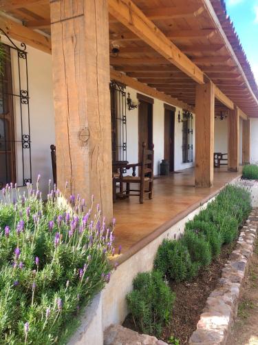 a porch of a house with purple flowers at Cortijo 7 in San Juan del Río