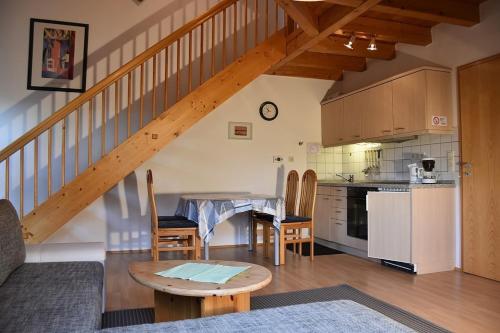 a kitchen and a living room with a staircase at Ferienhaus Nr 12B1, Feriendorf Hagbügerl, Bayr Wald in Waldmünchen