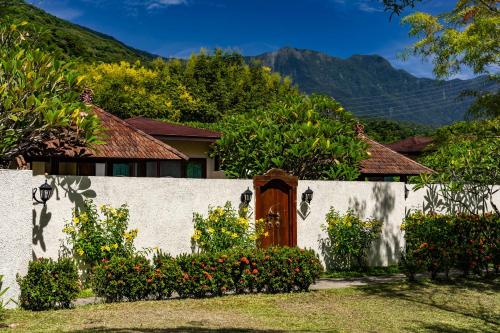 a house with a white wall with a wooden door at Bali Lover in Jian