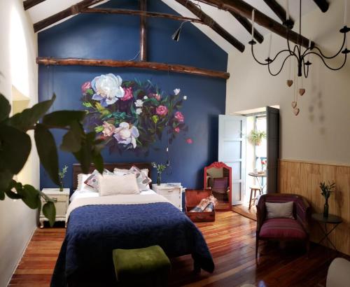 a bedroom with a bed with a blue wall at Niños Hotel Fierro in Cusco