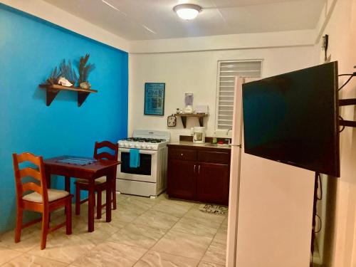 a kitchen with a table and a refrigerator at JAGUAR MORNING STAR in Caye Caulker