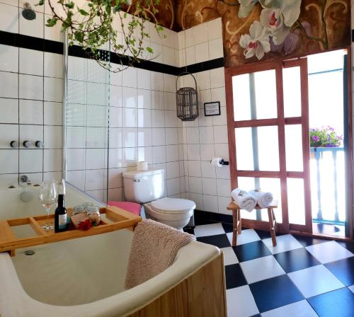 a bathroom with a bath tub and a toilet at Niños Hotel Fierro in Cusco