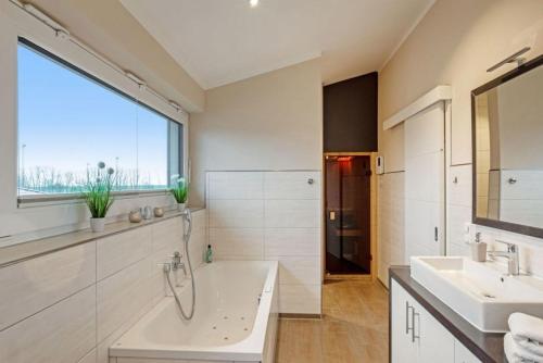 a bathroom with two sinks and a large window at Wellness - Ferienhaus Steilküste in Klausdorf