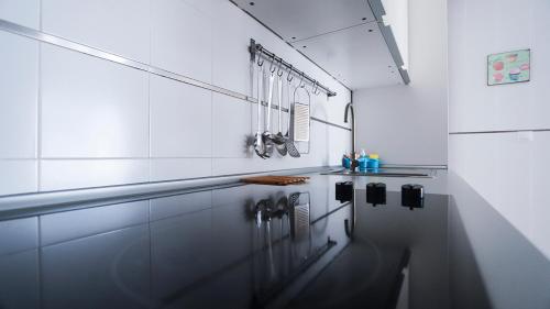 a white kitchen with a sink and a counter at La casa indaco, Puerto del Rosario, Fuerteventura in Puerto del Rosario