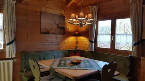a dining room with a wooden table and a chandelier at Blockhaus Stamsried in Stamsried