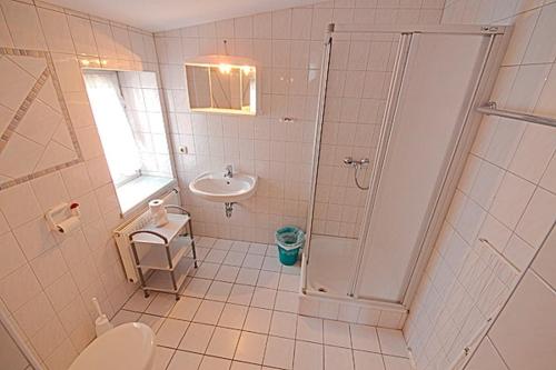 ein Bad mit einer Dusche, einem WC und einem Waschbecken in der Unterkunft St Michael 3, PP Grissini in Zingst
