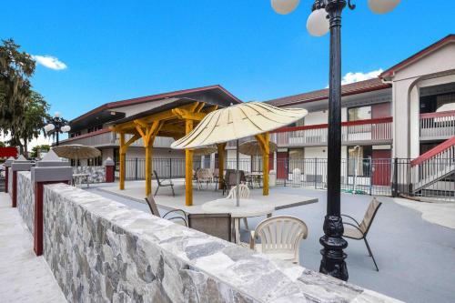 a patio with a table and chairs and an umbrella at Red Roof Inn Savannah – Southside/Midtown in Savannah