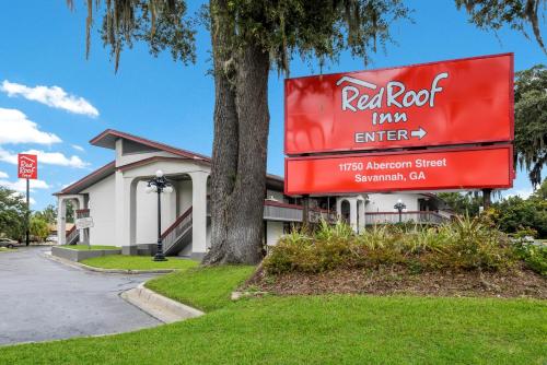 a sign in front of a building with a tree at Red Roof Inn Savannah – Southside/Midtown in Savannah