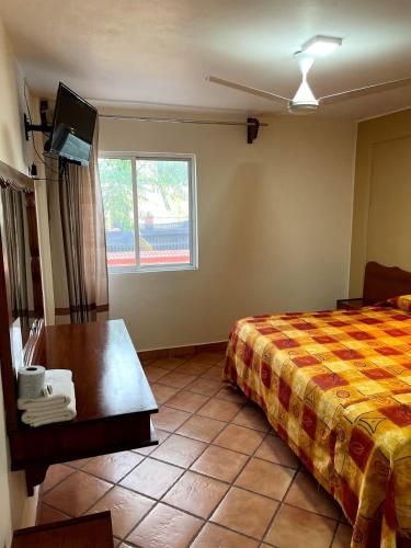a hotel room with a bed and a table and a window at HOTEL BUGAMBILIAS in Oaxaca City