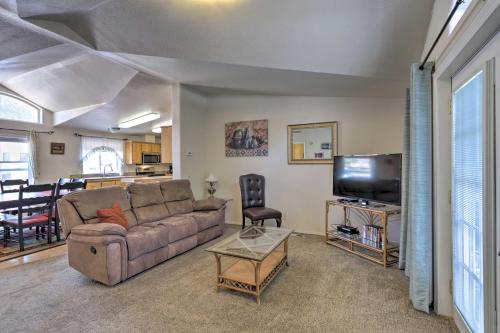 a living room with a couch and a tv at Red Rock Rambler Moab Home with Hot Tub and Views! in Moab