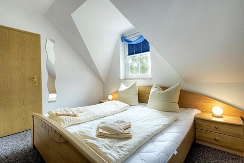 ツィングストにあるAm Deich 10のベッドルーム1室(白いシーツ付きのベッド1台、窓付)