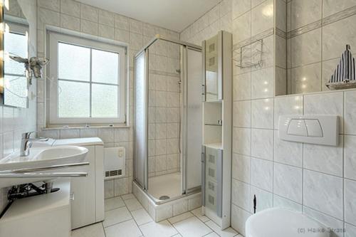 ツィングストにあるAm Deich 10の白いバスルーム(シンク、シャワー付)