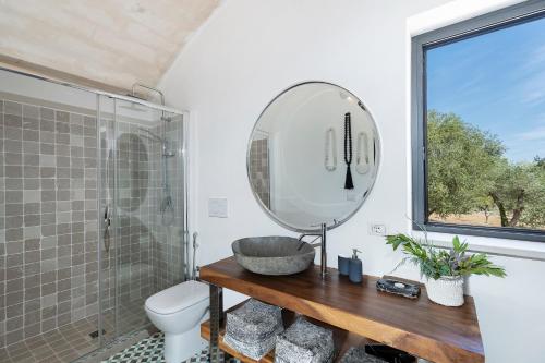 a bathroom with a sink and a mirror at trullo and lamia cinera in Cisternino