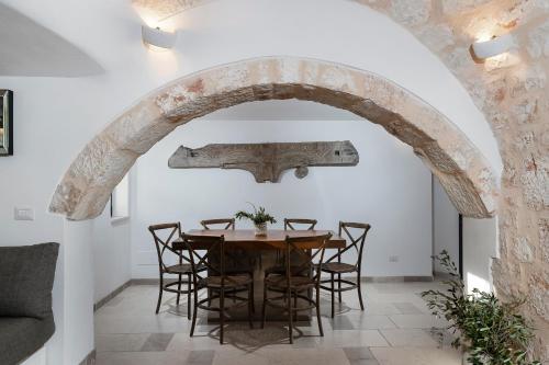 an archway in a dining room with a table and chairs at trullo and lamia cinera in Cisternino