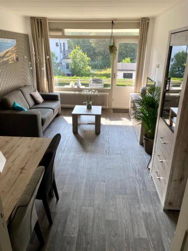 a living room with a couch and a table at Appartement Dishoek in Koudekerke