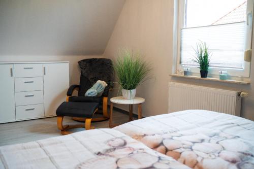 - une chambre avec un lit, une chaise et une fenêtre dans l'établissement Ferienhaus Uckerseeblick, à Prenzlau