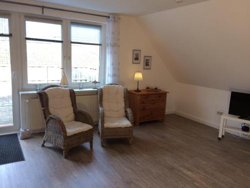 a living room with two chairs and a television at FeWo "Ahrens' Hüs" in Elsdorf-Westermühlen