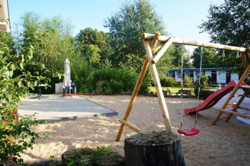 a playground with a slide and a swing set at Huus bi de Kark EG in Dahme