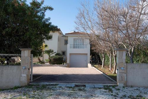 a white house with a gate and a garage at Villa Kiki in Peyia