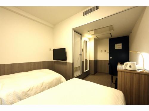 a hotel room with two beds and a television at Sendai Business Hotel Ekimae - Vacation STAY 71942v in Sendai
