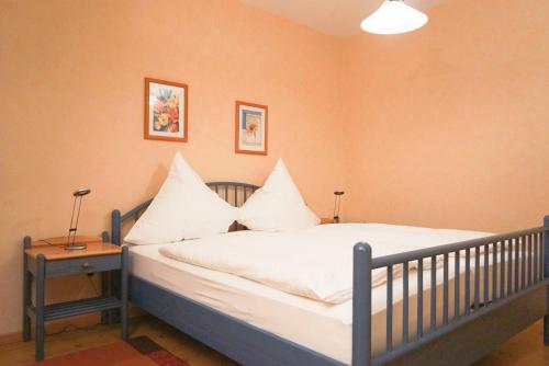 ヴァンガーオーゲにあるOsterdüne 66のベッドルーム1室(白いシーツと枕のベッド1台付)