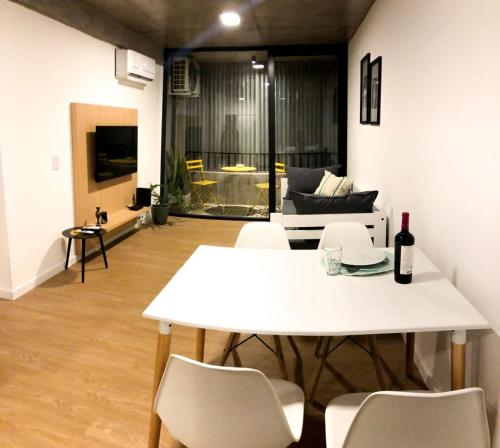 een woonkamer met een witte tafel en stoelen bij Cilveti 468 departamento con cochera, excelente ubicación in Rosario