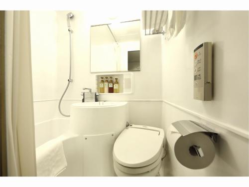 La salle de bains blanche est pourvue d'une douche et de toilettes. dans l'établissement Sendai Business Hotel Ekimae - Vacation STAY 71907v, à Sendai