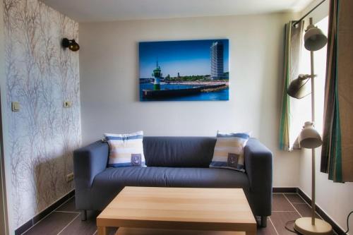 a living room with a blue couch and a table at Segellast 4 in Lübeck