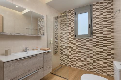 a bathroom with a sink and a toilet and a window at Villa Costa in Ixia
