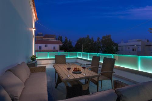a table and chairs on a balcony at night at Villa Costa in Ixia