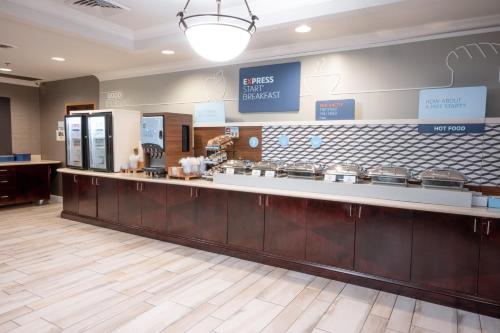 a restaurant with a large counter in a cafeteria at Holiday Inn Express & Suites - Tuscaloosa-University by IHG in Tuscaloosa