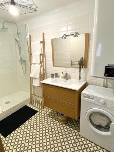 une salle de bain avec un lavabo et une machine à laver dans l'établissement Il y a le Soleil, la Campagne et la Mer …1, à Martigues