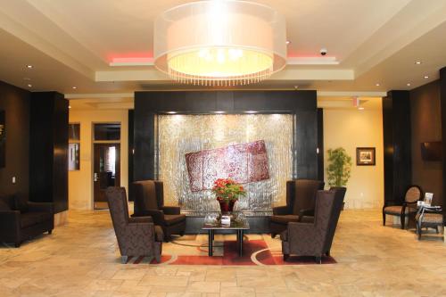 a lobby with chairs and a table and a painting at Best Western Sunrise Inn & Suites in Stony Plain