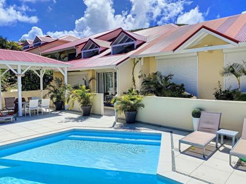 uma casa com piscina em frente a uma casa em Beautiful suite S14, pool, next to Pinel Island em Cul de Sac