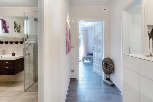 uma casa de banho com uma cabina de duche ao nível do chão e um lavatório. em Deichgraf Strandresidenz 1 Ahrenshoop em Zingst