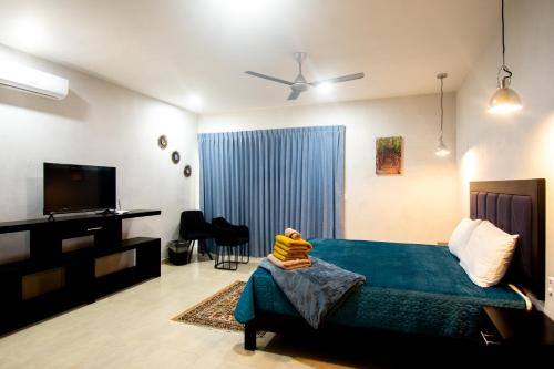 a bedroom with a bed and a flat screen tv at Hotel Casa Tortuga Tulum - Cenotes Park Inclusive in Tulum
