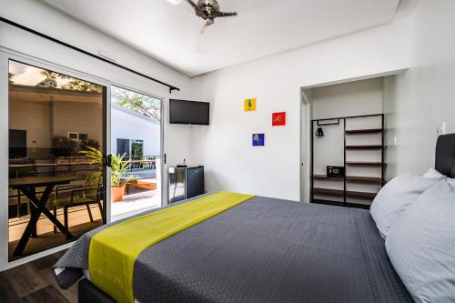 a bedroom with a large bed and a balcony at Hotel Elixir in Tamarindo