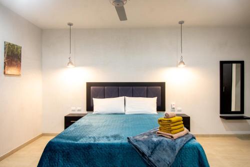 a bedroom with a bed with a blue comforter at Hotel Casa Tortuga Tulum - Cenotes Park Inclusive in Tulum