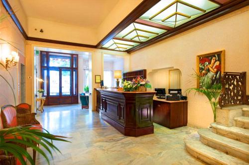 een grote kamer met een lobby met een trap bij Grand Hotel Regina Salsomaggiore in Salsomaggiore Terme
