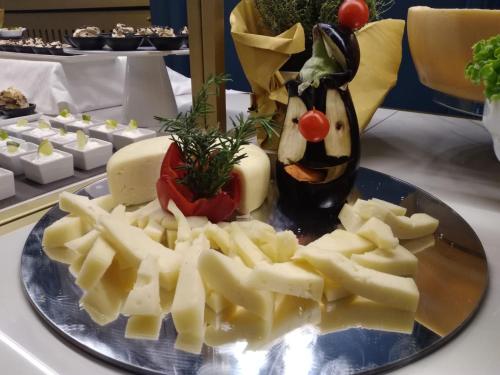 a plate of food with cheese and a statue of a person at Grand Hotel Regina Salsomaggiore in Salsomaggiore Terme